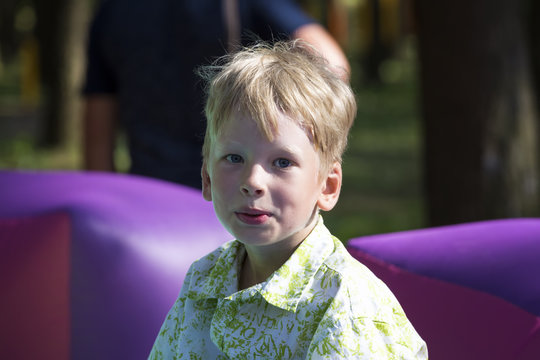 Smiling  boy on inflatable trampolina outdoors