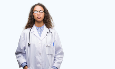 Young hispanic doctor woman with a confident expression on smart face thinking serious