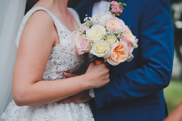 Obraz na płótnie Canvas Bride and groom holding bouquet