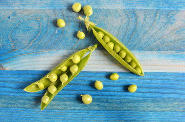 juicy peas on blue wooden background