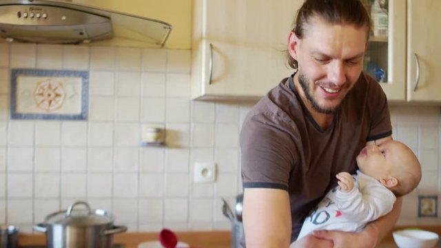 The guy feeds the baby from the nipple, kisses him on the forehead. He lifts him in his arms, puts it in a column, belches. The kid smiles and turns his head. Care for babies up to a year.