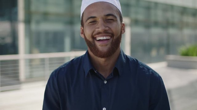 portrait of young middle eastern man standing laughing office outdoor campus businessman