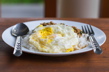 Rice topped with fried egg and stir-fried pork basil