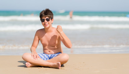 Young child on holidays at the beach screaming proud and celebrating victory and success very excited, cheering emotion
