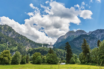 Fototapeta premium Idyllic landscape in the Alps with green meadows and clouds