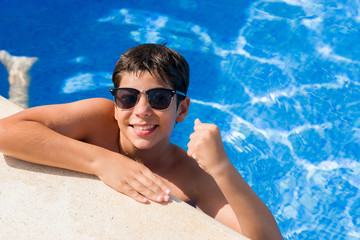 Young child on holiday at the swimming pool by the beach screaming proud and celebrating victory and success very excited, cheering emotion