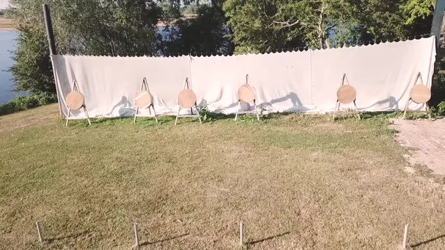 Drone shot, following the path of a thrown object towards the target.