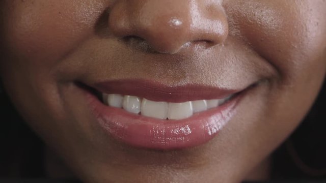 close up of african american woman glossy lips smiling happy showing healthy teeth beautiful perfect skin