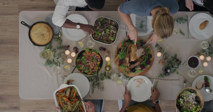 top view young diverse friends enjoying thanksgiving lunch together making toast bonding over delicious homemade meal tracking