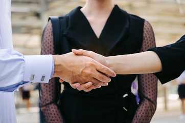 midsection group of young Arabian man handshake with business woman after finishing up meeting in modern city background, partnership, teamwork, community, connection financial and investment concept