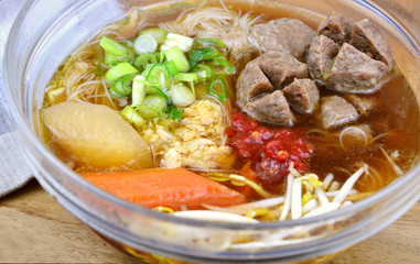 Thai street food Beef ball and thin rice noodles with dark soup.