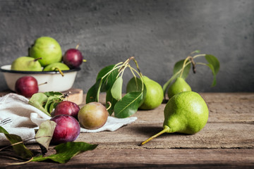 concept of the harvest of autumn and thanksgiving. Seasonal fruit pear and plum on a wooden table in rustic style with copy space