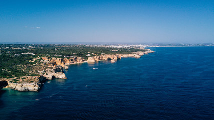 Naklejka na ściany i meble Aerial view of Algarve coast. Beautiful natural beaches with cliff and rocks from above