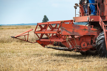 combine harvester that is harvesting wheat on summertime