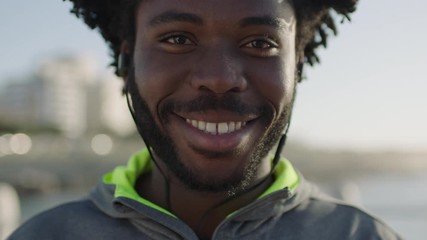 close up portrait of young lively african american man smiling confident wearing sporty fashion enjoying happy healthy lifestyle seaside background