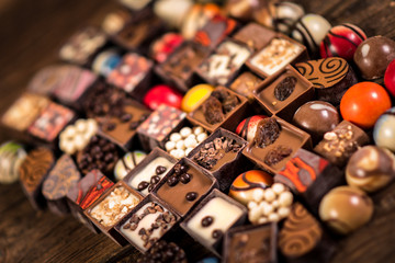 Assorted chocolate pralines on the wooden background