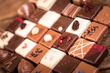 Assorted chocolate pralines on the wooden background