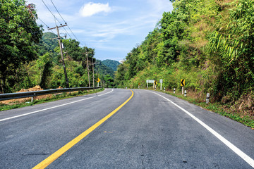 Obraz premium Country road in the mountains with forest