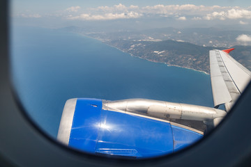 Fototapeta premium A beautiful view through the porthole of the plane on the Mediterranean coast, in the Antalya region, Turkey
