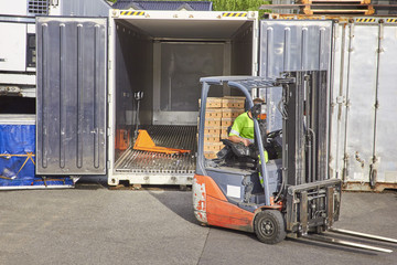 Worker on forklift loading car