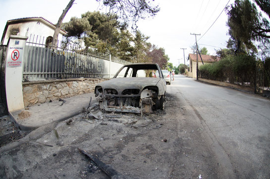 Fires destroy Greece village Burnt car on road. Burnt tire and molten metal out of house