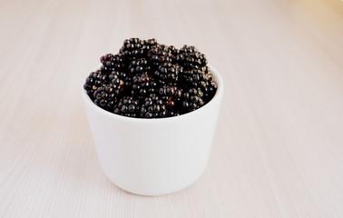 Fototapeta na wymiar Blackberry in the cup. Summer berry