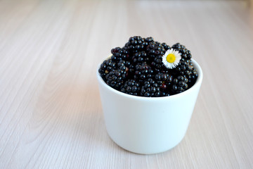 Fototapeta na wymiar Blackberry in the cup. Summer berry