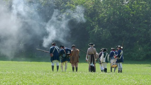 Amercian Revolutionary War Reenactors fire at enemy