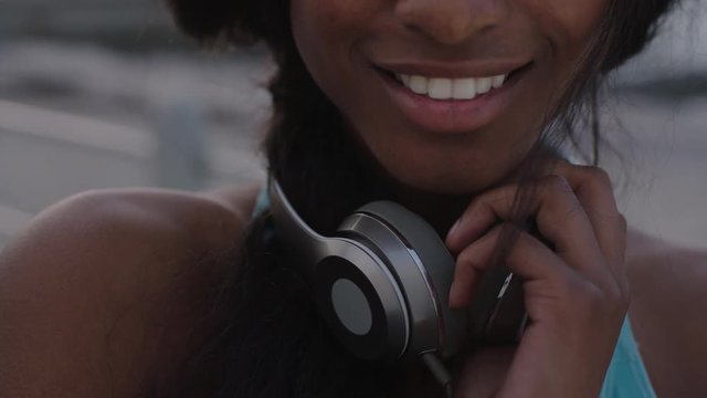 close up portrait of attractive woman holding headphones smiling to camera