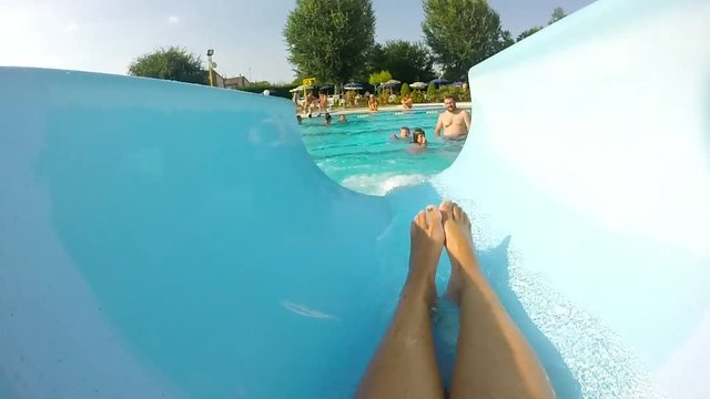ragazza che scende da uno scivolo in piscina