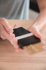 Woman holding a cell phone with a credit card