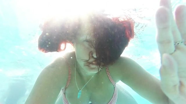 ragazza che nuota sott'acqua in immersione