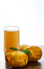 glass of potato juice on wooden table on white background with copy space.