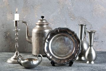 Vintage silver tableware on concrete background