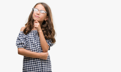 Brunette hispanic girl wearing glasses serious face thinking about question, very confused idea