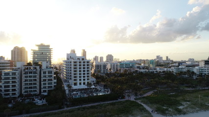 Aerial view of the sun setting behind the Miami skyline.