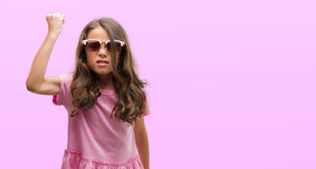 Naklejka premium Brunette hispanic girl wearing sunglasses annoyed and frustrated shouting with anger, crazy and yelling with raised hand, anger concept
