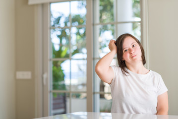 Down syndrome woman at home confuse and wonder about question. Uncertain with doubt, thinking with hand on head. Pensive concept.