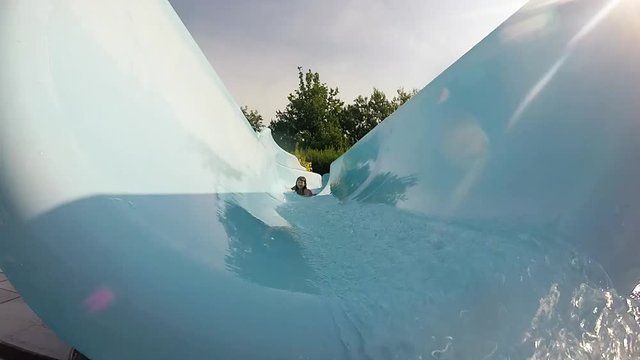bambina che scende da uno scivolo acquatico