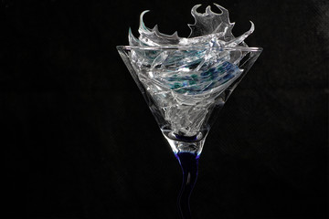 Broken glass in front of black background photographed under the name glass shards cocktail
