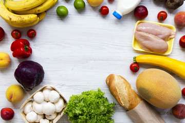 Frame of healthy food on white wooden table. Cooking food background. Flat lay of fresh fruits, veggies, greens, meat, milk. Top view, overhead, from above. Shopping concept. Copy space.