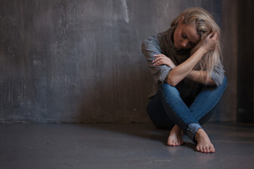Depressed woman. blonde girl sitting on the floor, sadness and depression