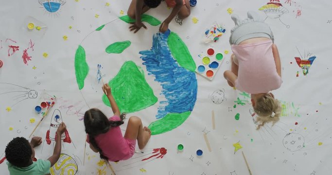 multi ethnic children paint colorful pictures together on paper using paint brushes happy kids enjoying fun creativity painting science fiction space drawing pictures top view