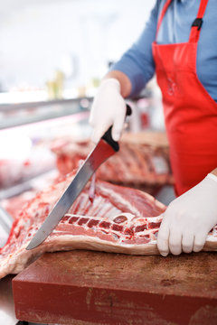 Close-up of butcher cutting quality porks