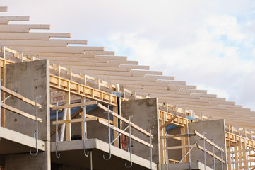 New home construction with concrete walls, balconies and roof trusses.