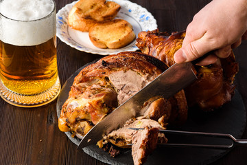 Meat foreshank on a stone plate whith beer and bread