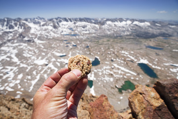 Hand Holding Cookie On Mountain Top