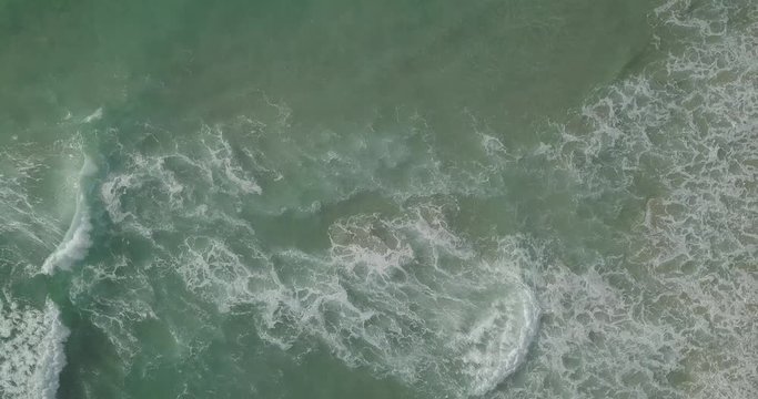 Drone zoom out of the seawater from above.
