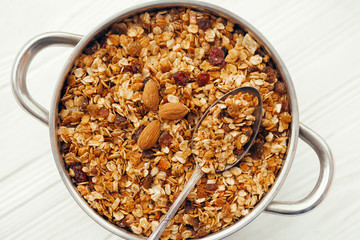 delicious granola muesli with nuts and raising in big bowl with vintage spoon, flat lay. healthy breakfast concept. cereal meal flat lay