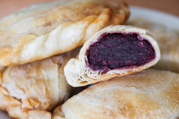 Bakery homemade,Curry puff with stuffed purple sweet potato on wooden desk.